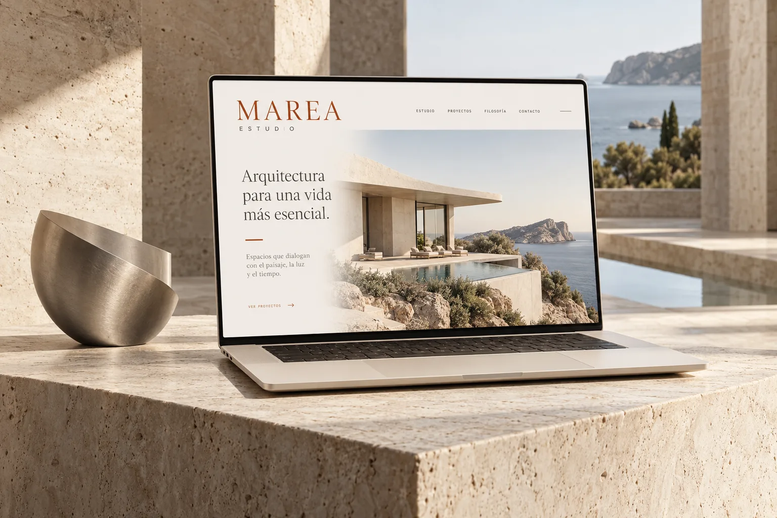 Mockup conceptual de MAREA: una web de arquitectura en un portátil sobre piedra clara, junto a una pieza escultórica.